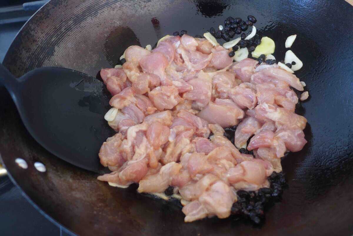 marinated chicken pieces in a wok.