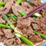 chopsticks picking up a piece of beef.