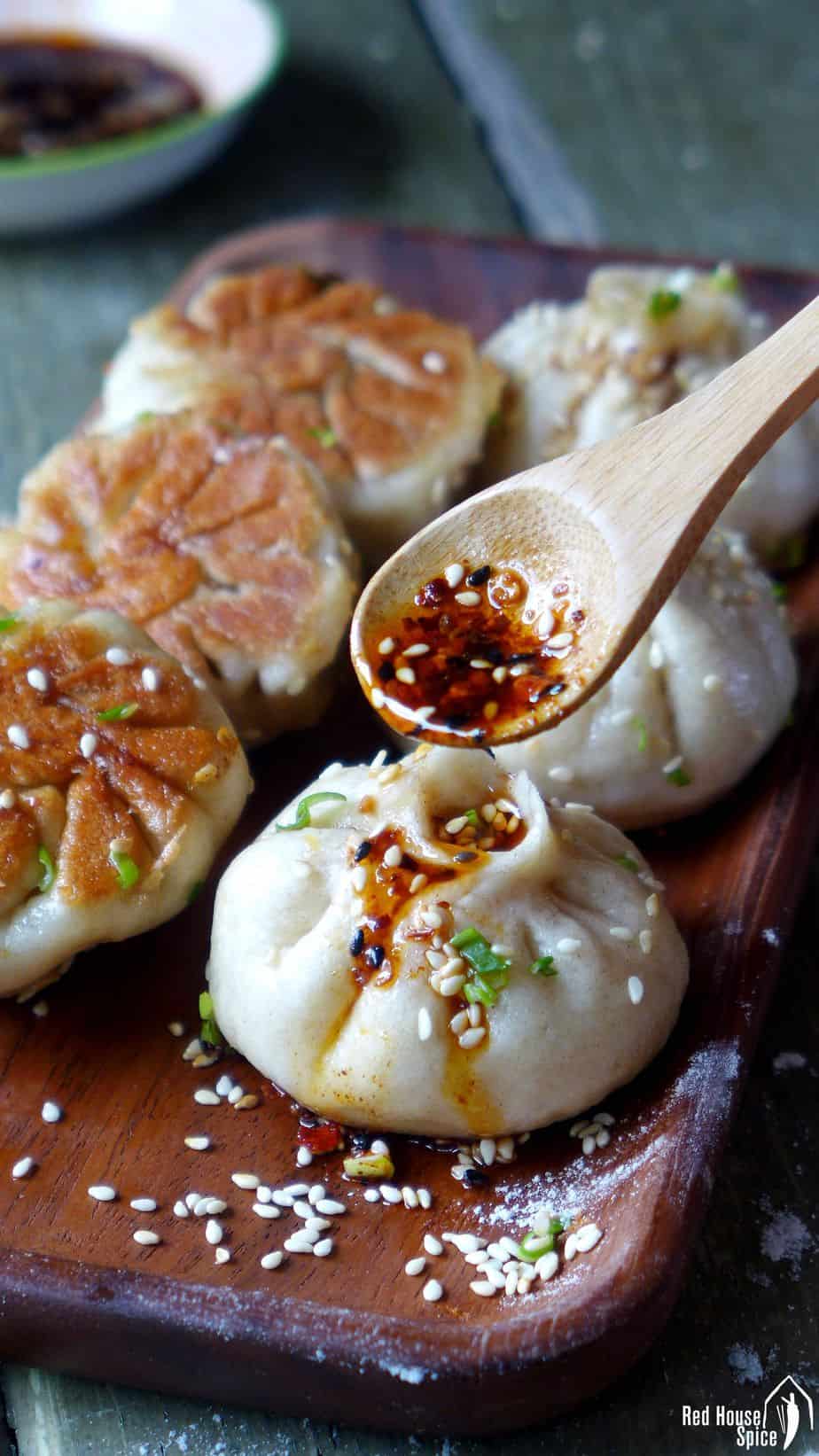 Six freshly cooked Sheng Jian Bao (生煎包, pan-fried pork buns) served with Chinese chilli oil.