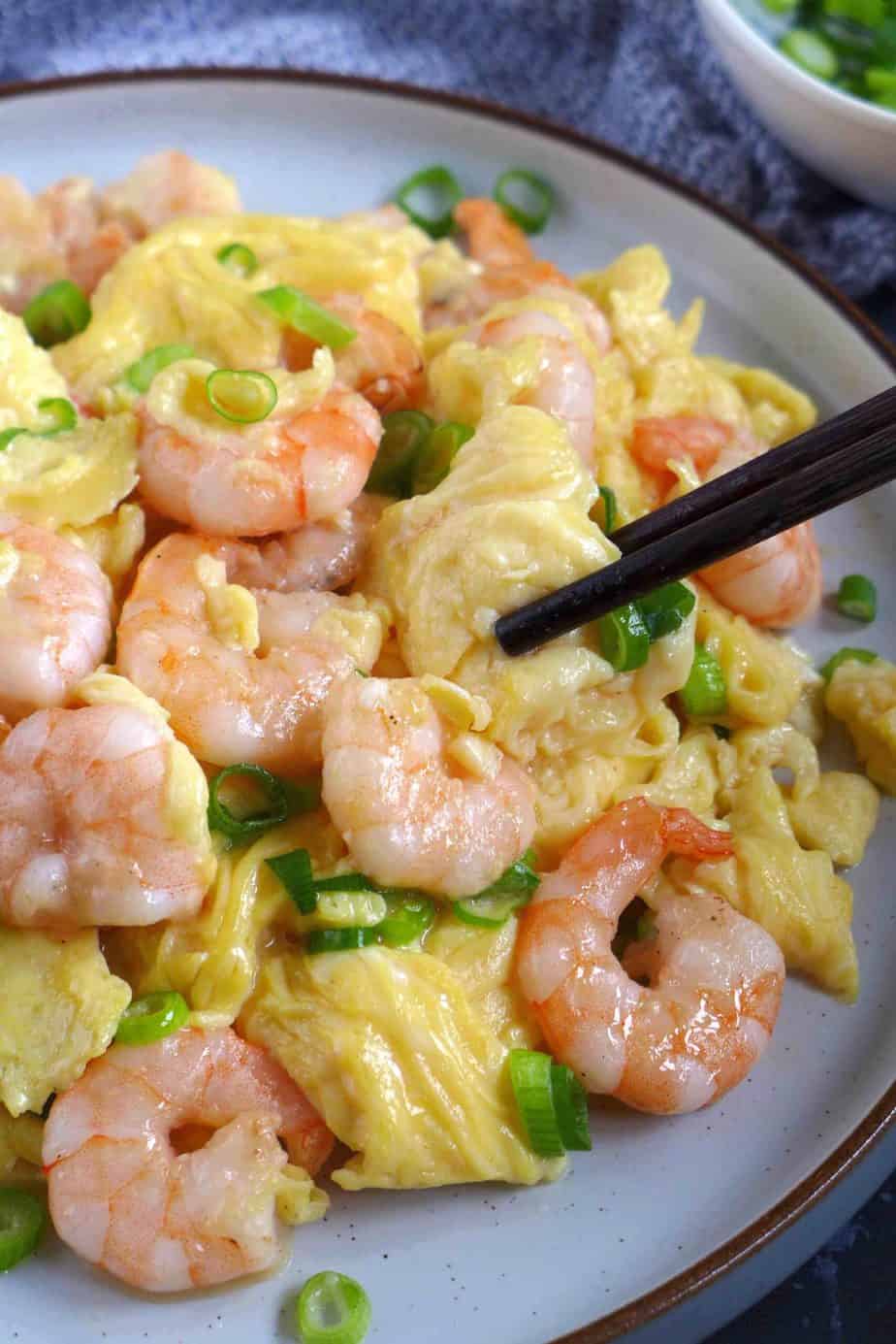 Chopsticks picking up stir-fried shrimp and eggs