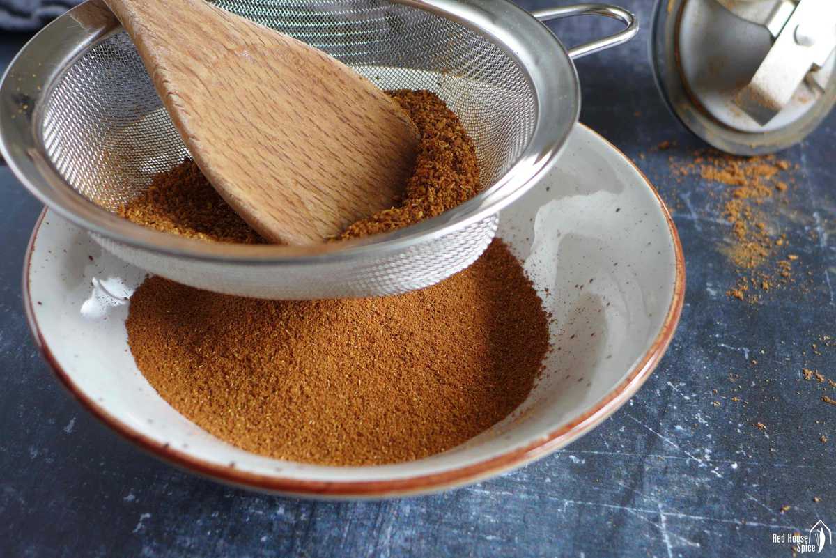 Sifting five spice powder through a sieve.