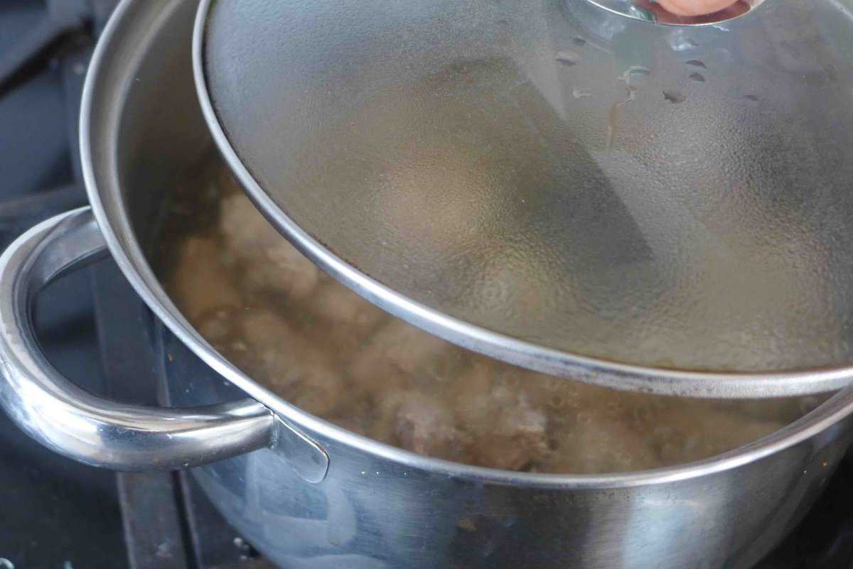 covering a pot of simmering pork ribs.
