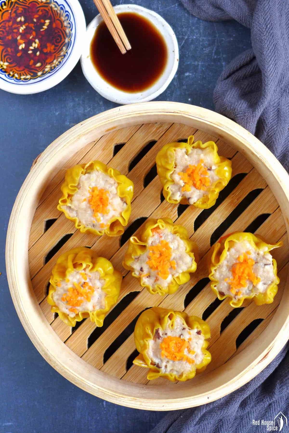 six cooked Siu Mai in a bamboo steamer.
