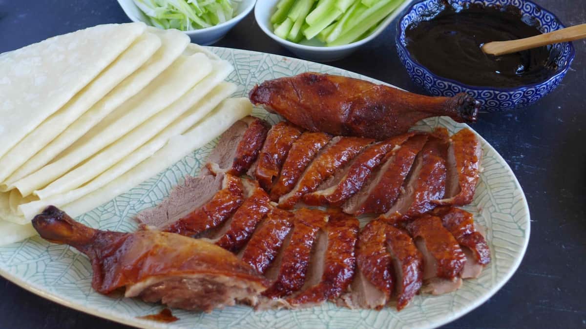 sliced Peking duck with thin pancakes, dark sauce, and julienned vegetables