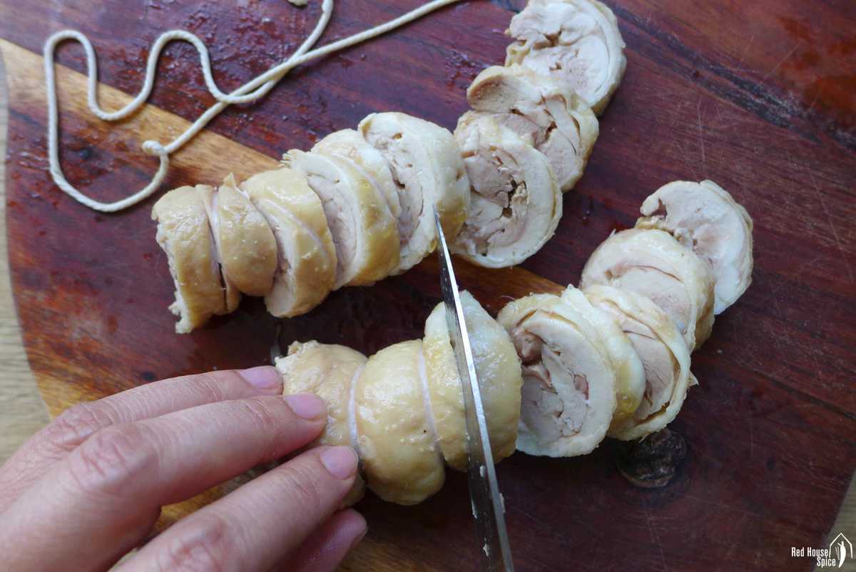 slicing two cooked chicken rolls