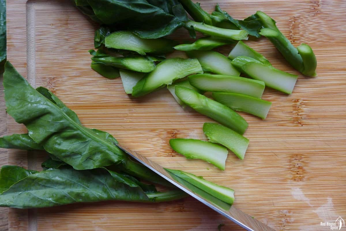 slicing Chinese broccoli.