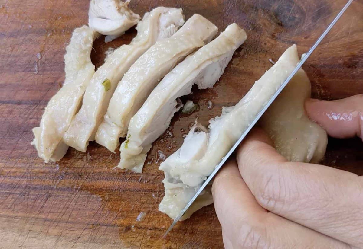 slicing cooked chicken thigh