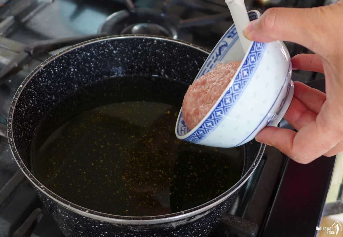 Sliding a meatball into hot oil