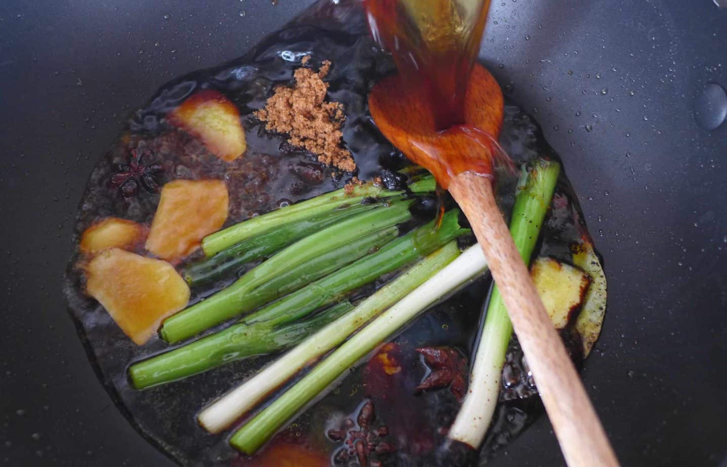 pouring sauce soy into a wok