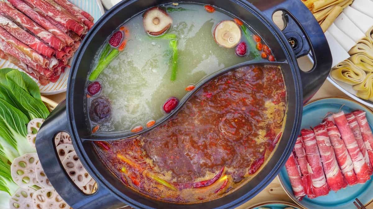 a divided pot filled with spicy and mild broth