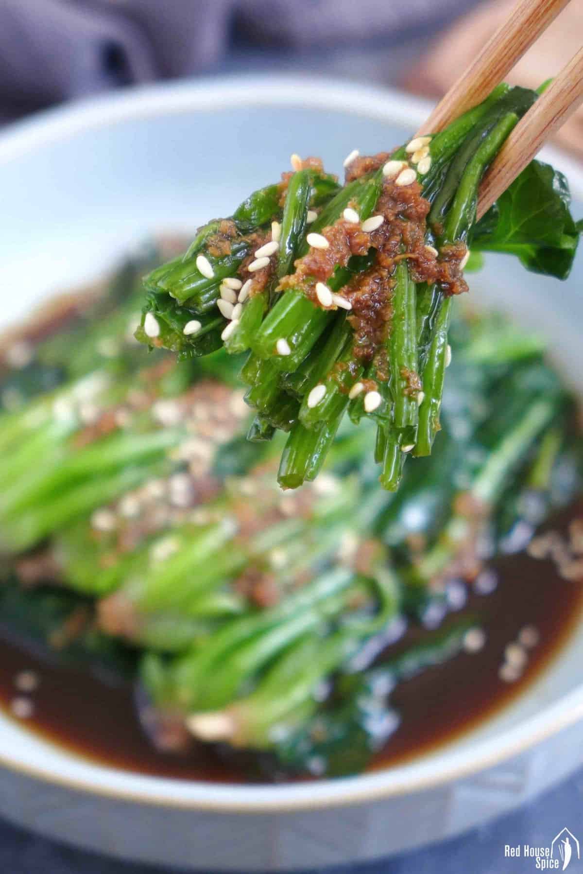 chopsticks picking up spinach salad.
