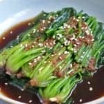blanched spinach with a ginger soy dressing with overlay text that says chinese spinach salad.