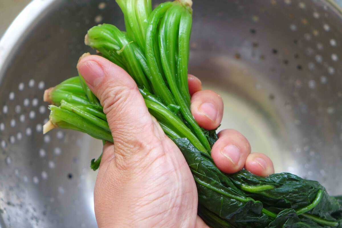 squeezing cooked spinach.