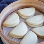 cooked plain bao buns in a steamer.