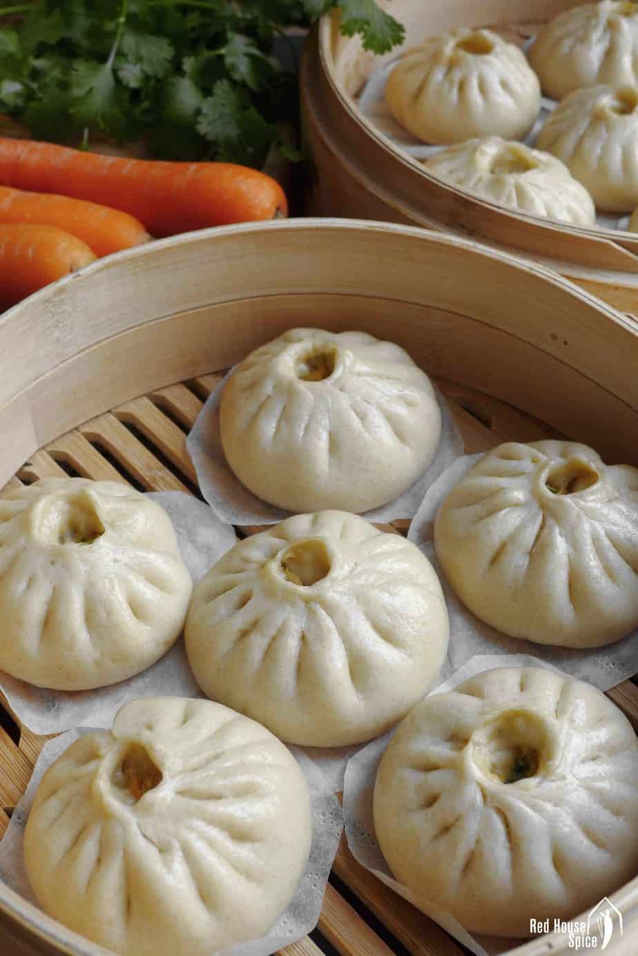 Fluffy bao buns in a bamboo steamer.
