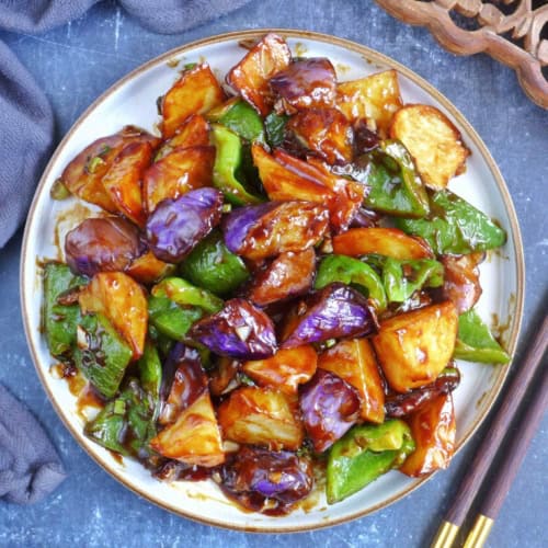 A plate of stir-fried eggplant, potato and pepper.
