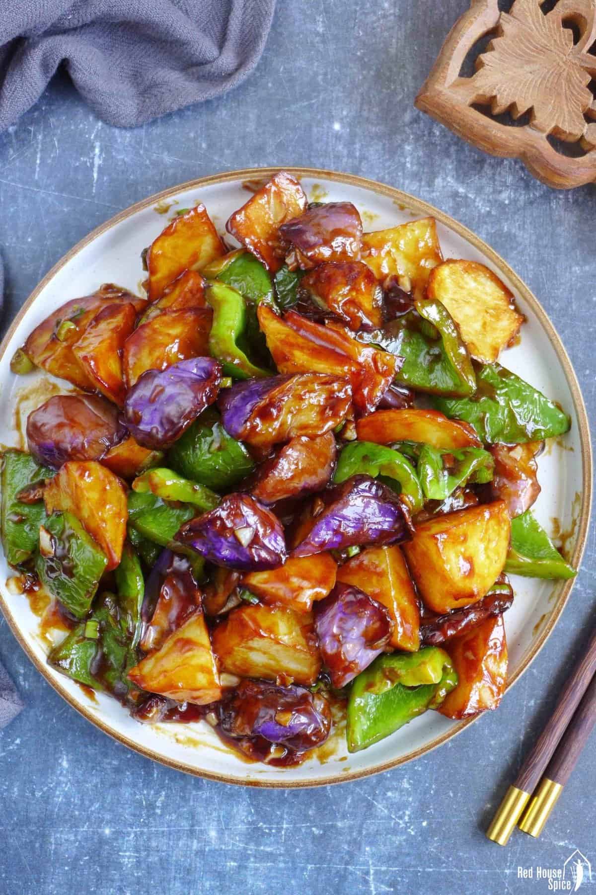 A plate of stir-fried eggplant, potato and pepper.