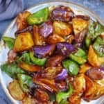 A plate of stir-fried eggplant, potato and pepper with overlay text that says Di San Xian stir-fry.