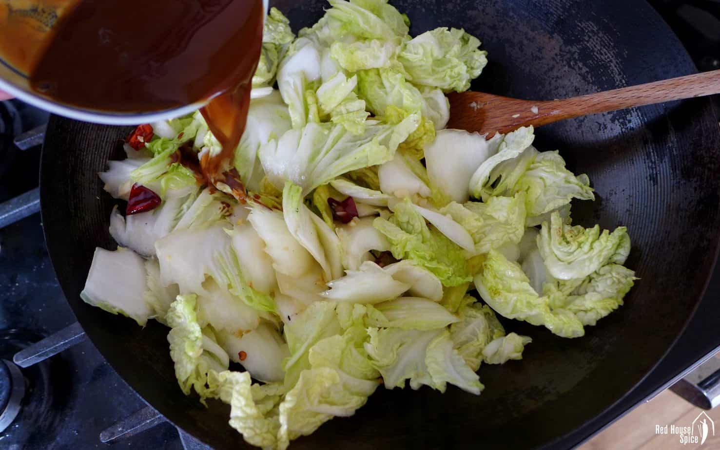 Pouring sauce onto stir-fried napa cabbage