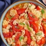 tomato and egg stir-fry in a plate with overlay text that says tomato egg stir-fry.