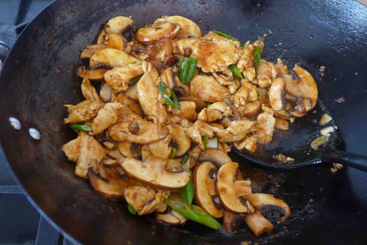 Stir-frying chicken with mushrooms.