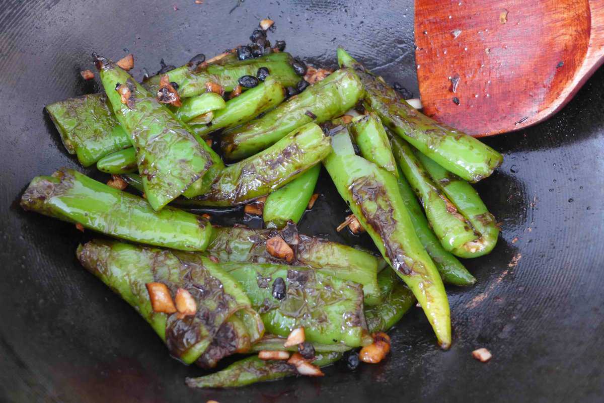 stir-frying chili pepper in a wok.