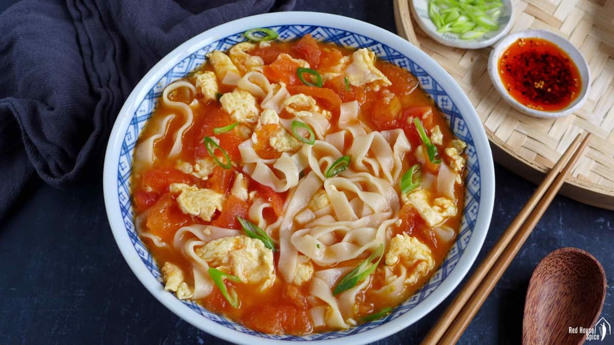 Noodles with tomato and egg soup in a bowl