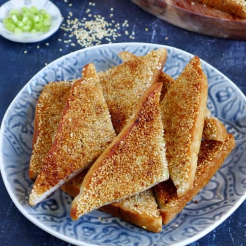 Pieces of sesame shrimp toast on a plate.