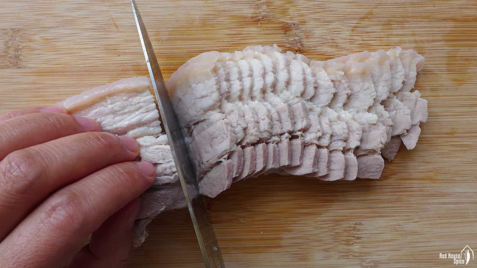 Slicing a piece of boiled pork belly