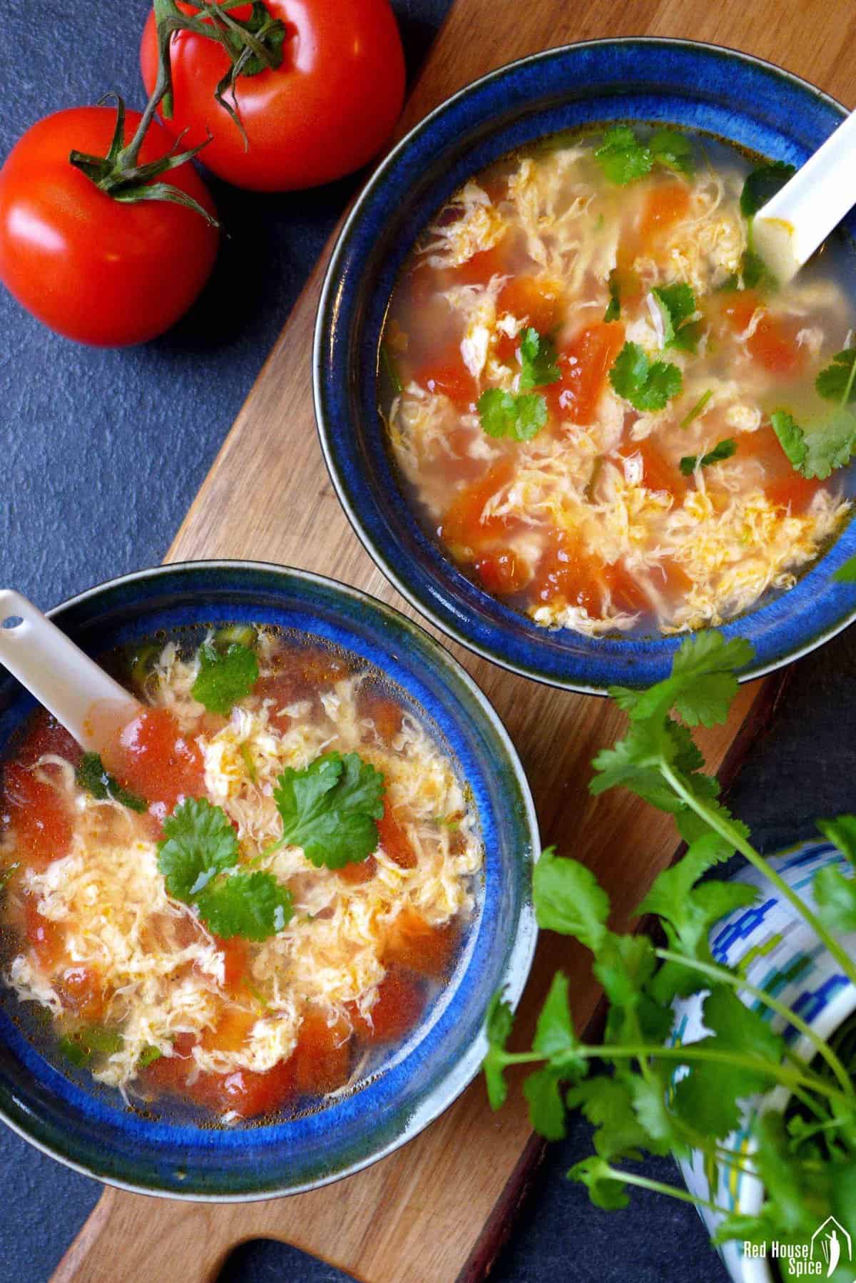 Two bowls of chinese tomato egg drop soup.