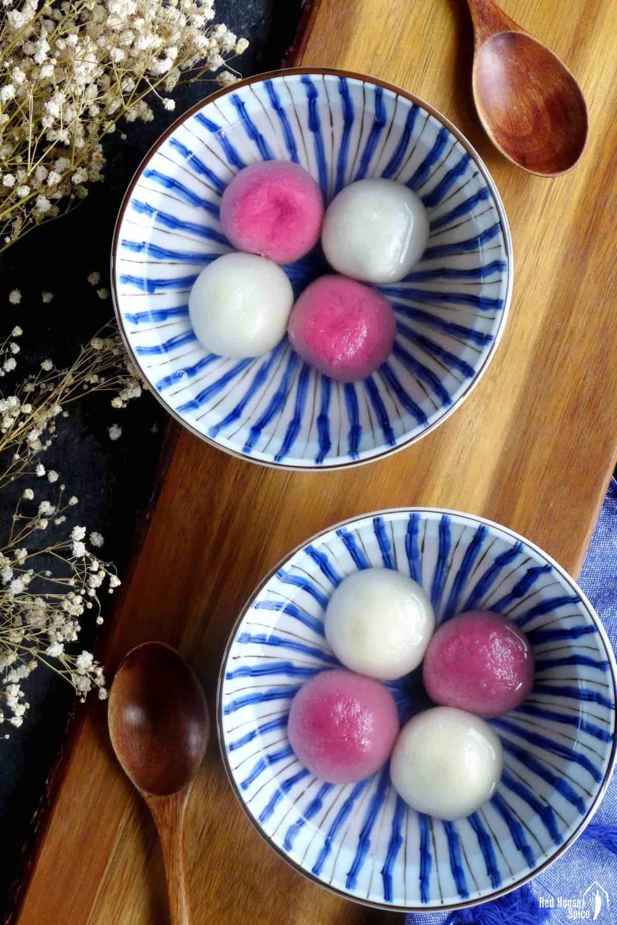 two bowls of white and pink tang yuan.