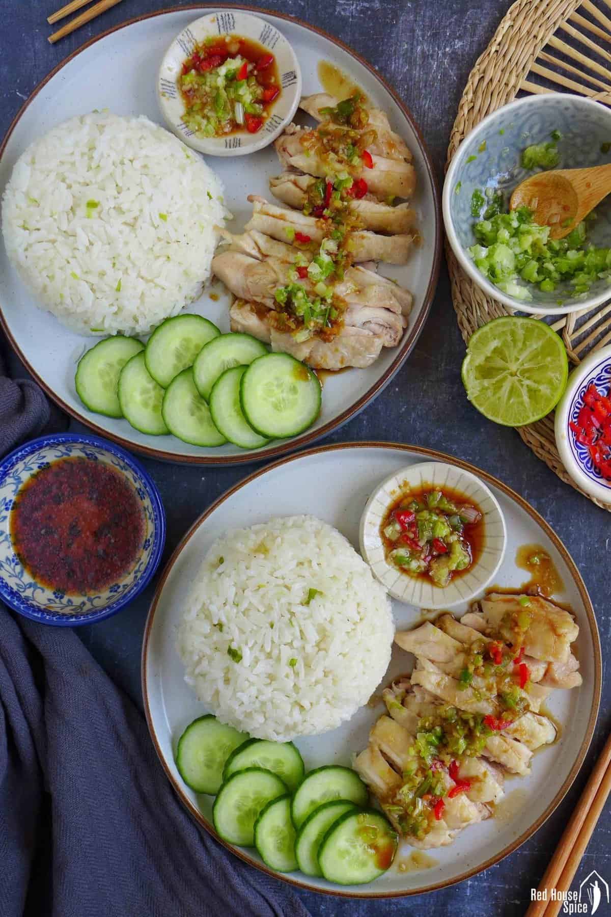 two plateful of hainanese chicken rice with seasonings on the side