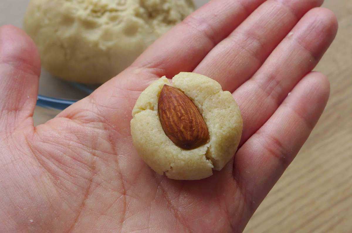 a round cookie rough with an almond on top.