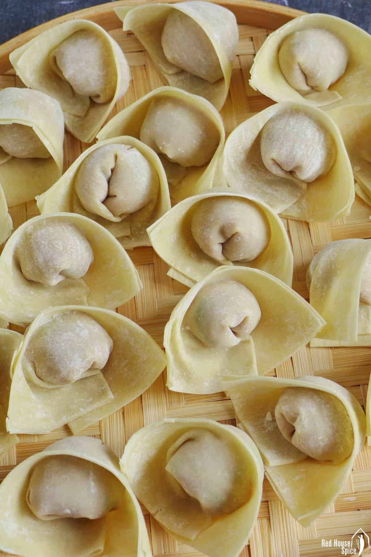 uncooked wontons on a tray.