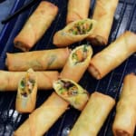 whole and halved vegan spring rolls on a tray.