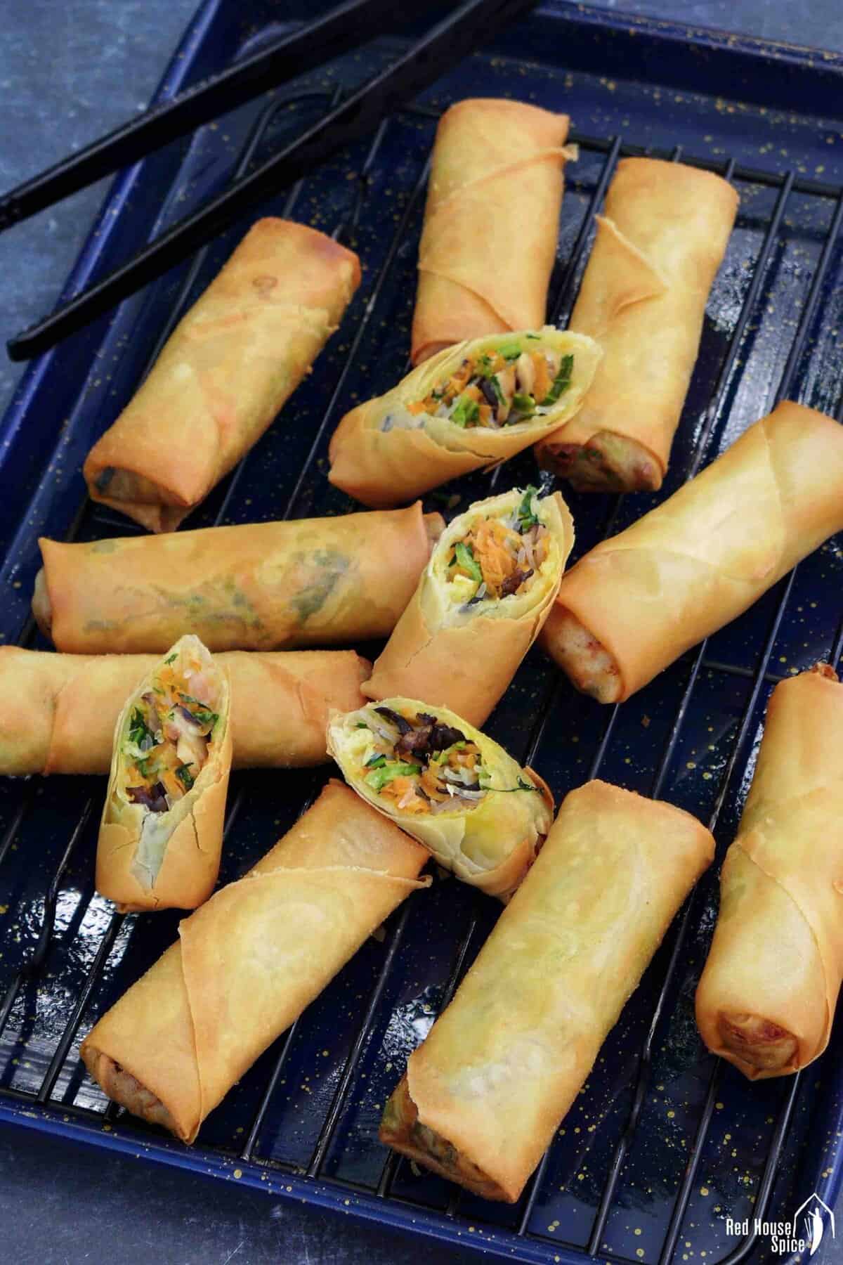 whole and halved vegan spring rolls on a tray.