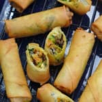 whole and halved vegan spring rolls on a tray.