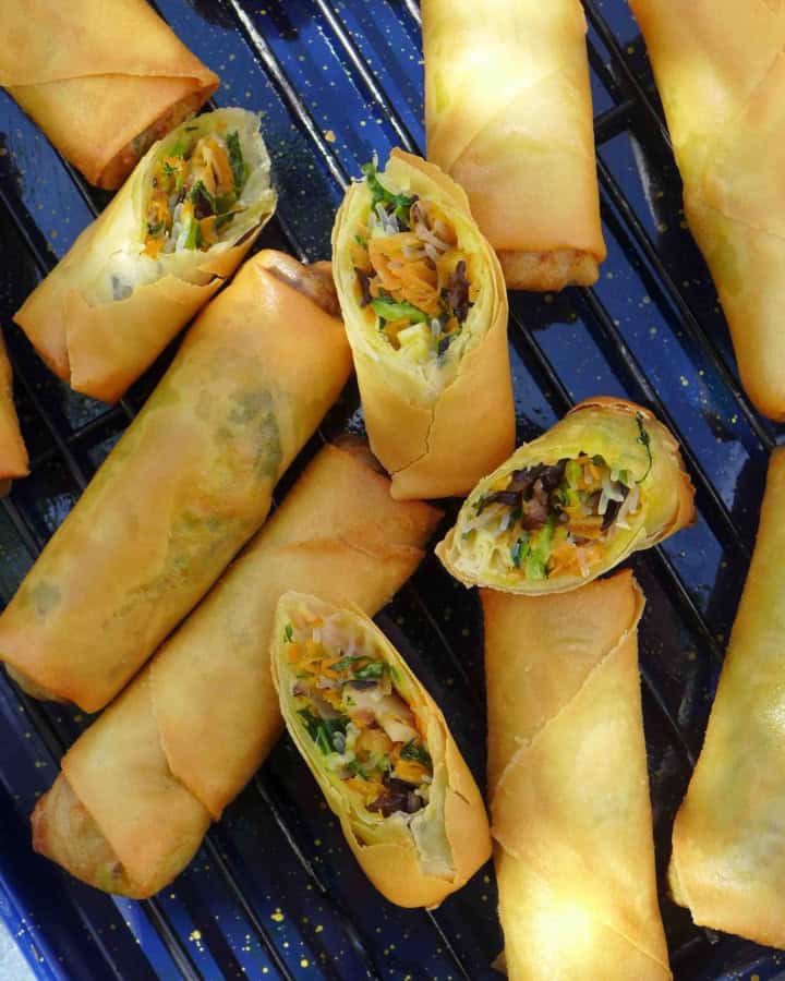 whole and halved veggie and tofu spring rolls on a tray.