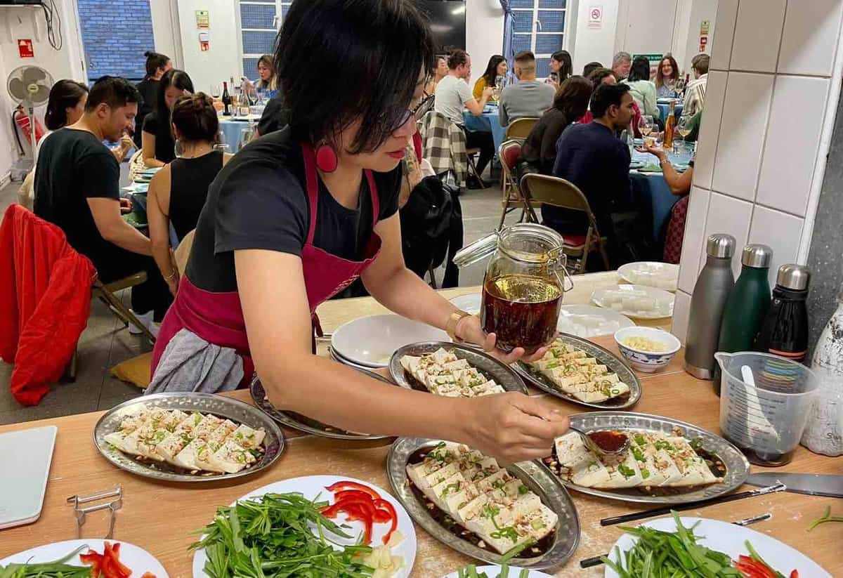 Wei Guo prepares food for a fund-raising supper club.