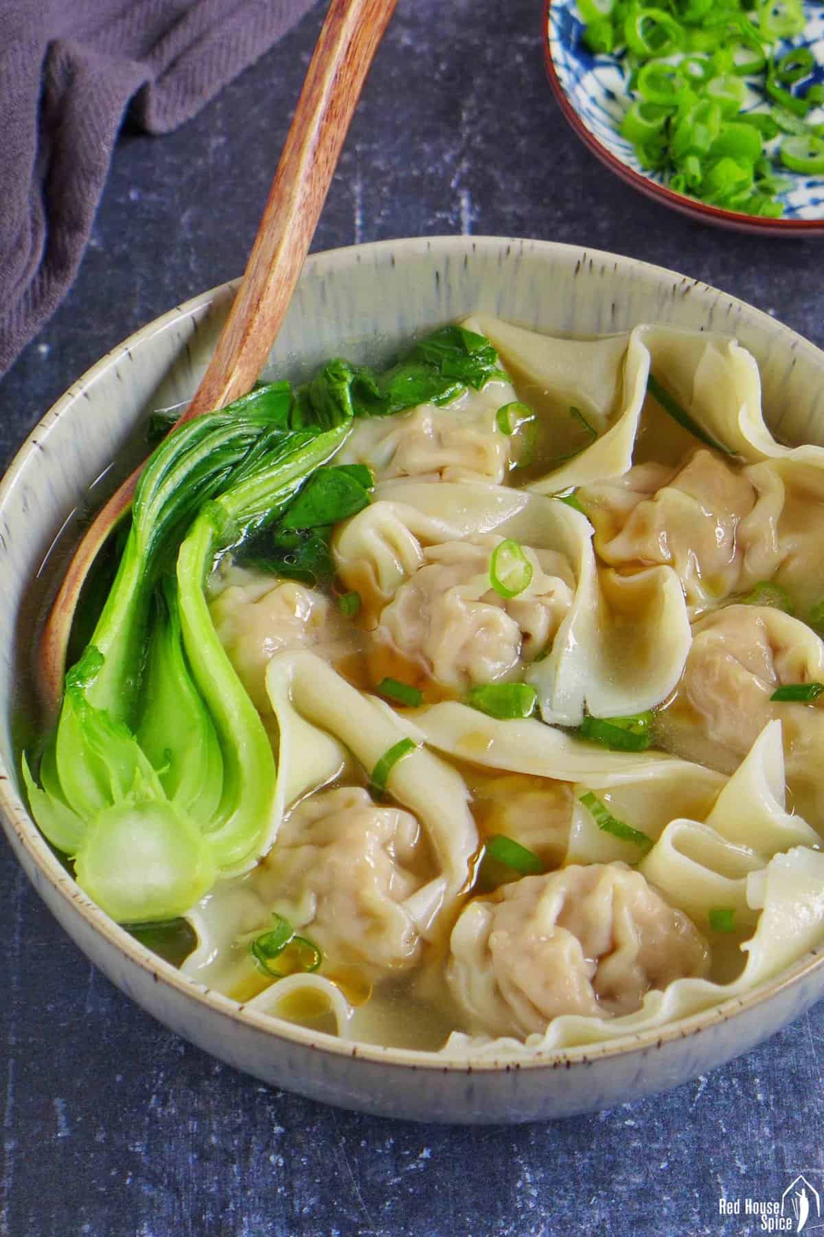 cooked wontons in soup with blanched Bok Choy.