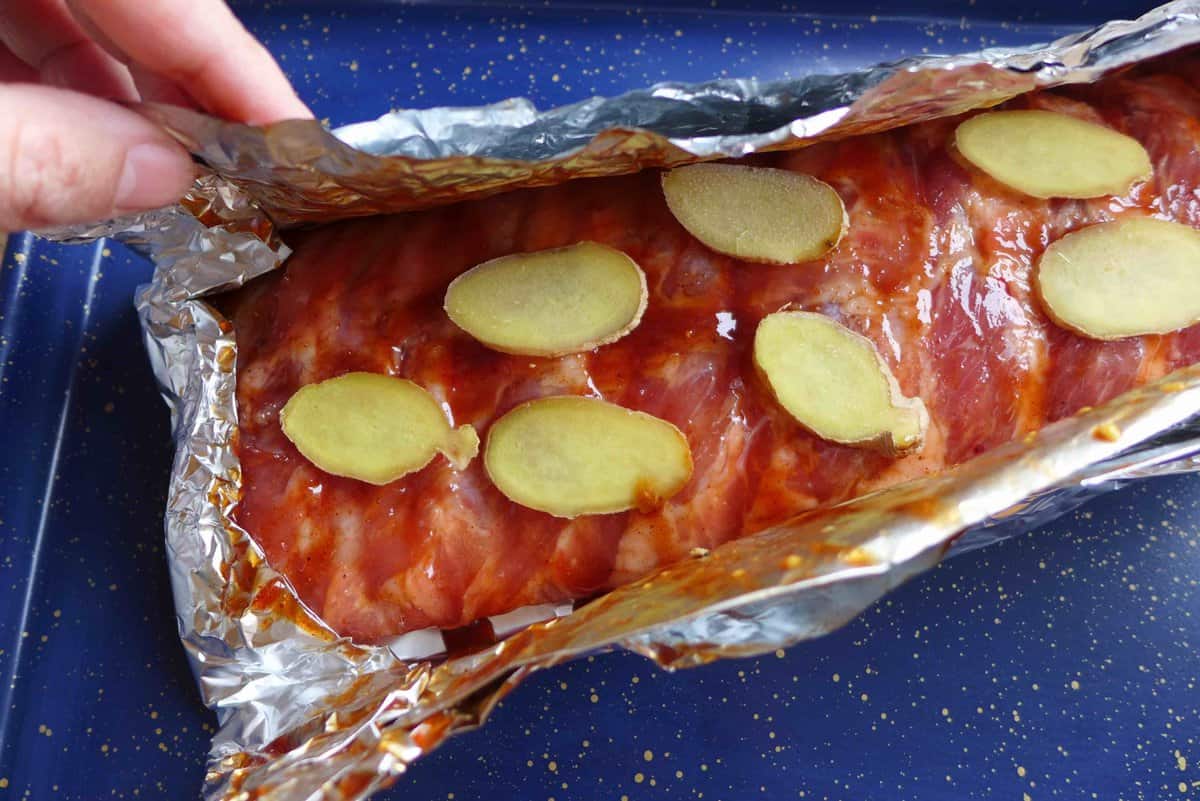 wrapping marinated ribs and ginger with foil.