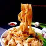 Hand pulled Biang Biang noodles lifted by a pair of chopsticks
