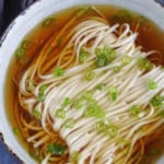 A bowl of noodle soup with overlay text that says Yang Chun Noodle Soup.