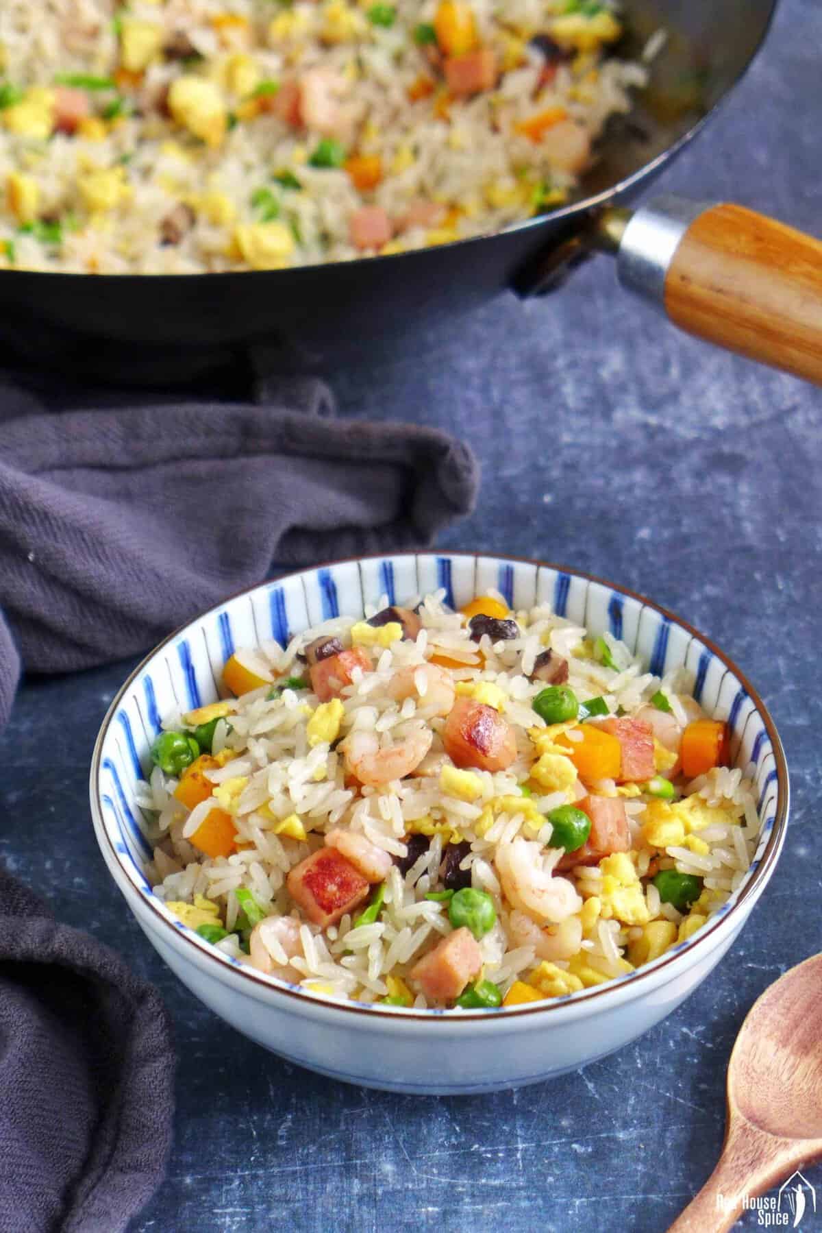 Yanzhou fried rice in a bowl and in a wok.