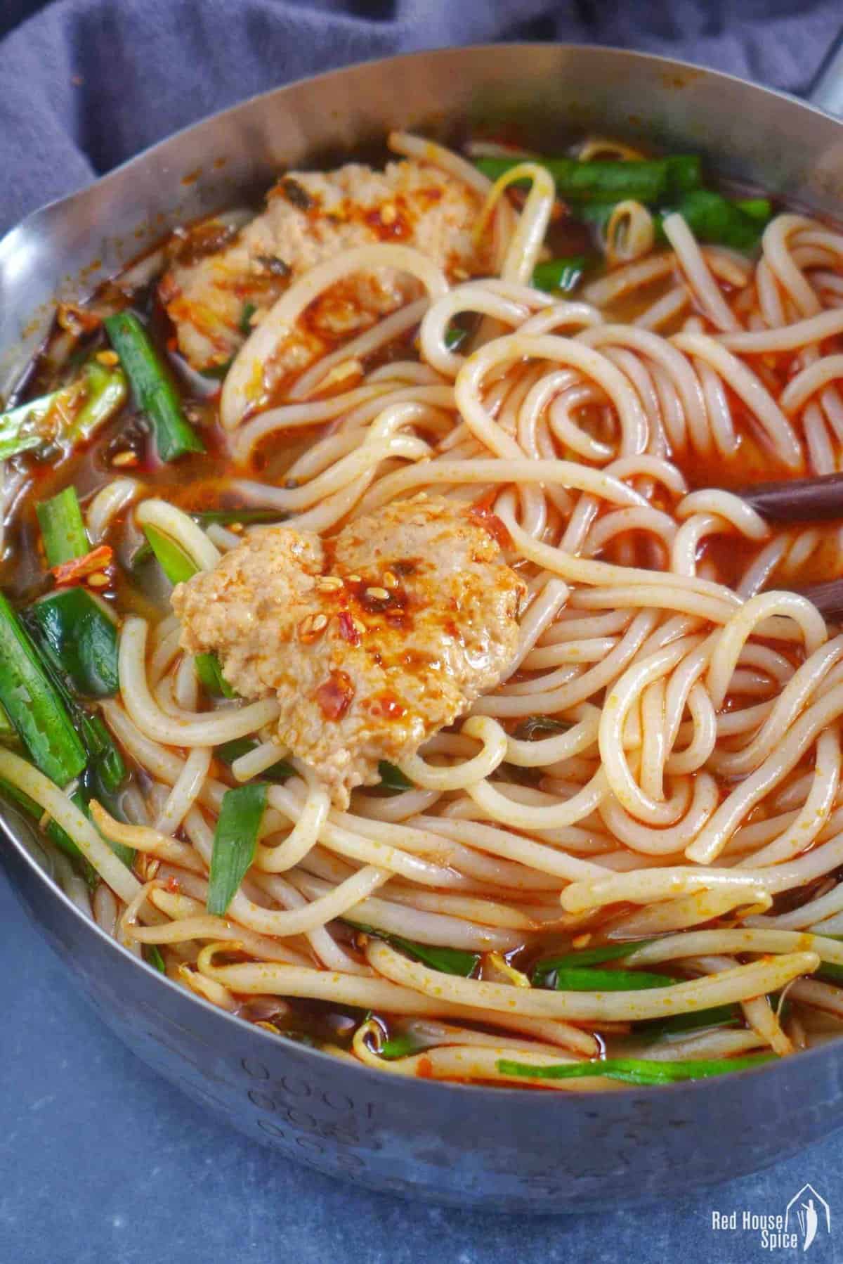 Yunnan rice noodle soup in a small pot.