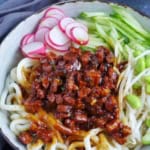 a bowl of Zha Jiang Mian with overlay text that says fried sauce noodles.